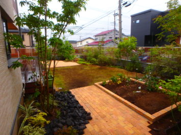 横須賀のいろは苑が横浜市で作った、菜園とレンガのテラスと芝生のある庭